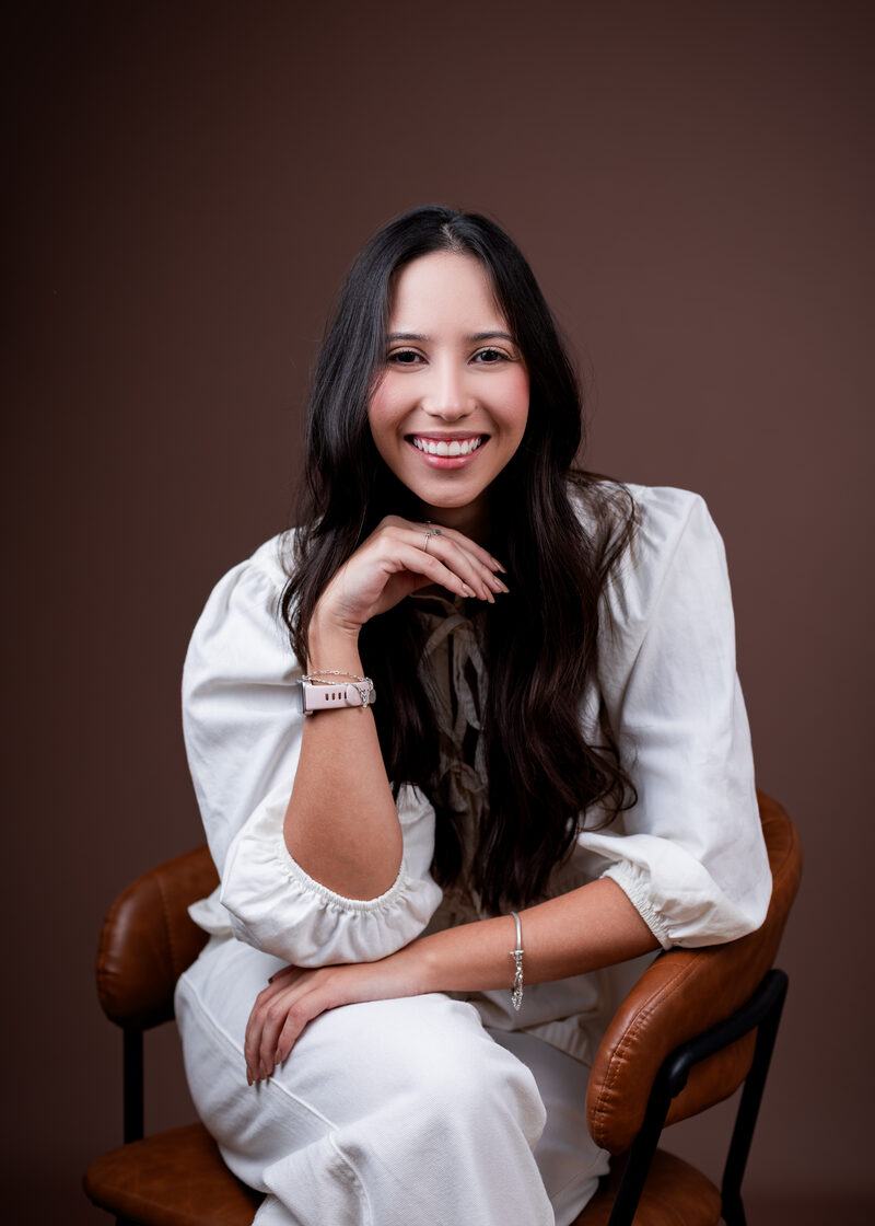 Retrato de Maria Tereza Barreto sorrindo, com o queixo apoiado na mão